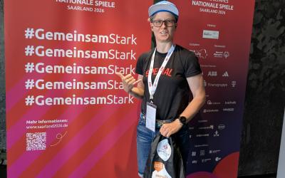 Athletin Judith Hendriks posiert vor dem Special Olympics Banner 'GemeinsamStark' im Saarland